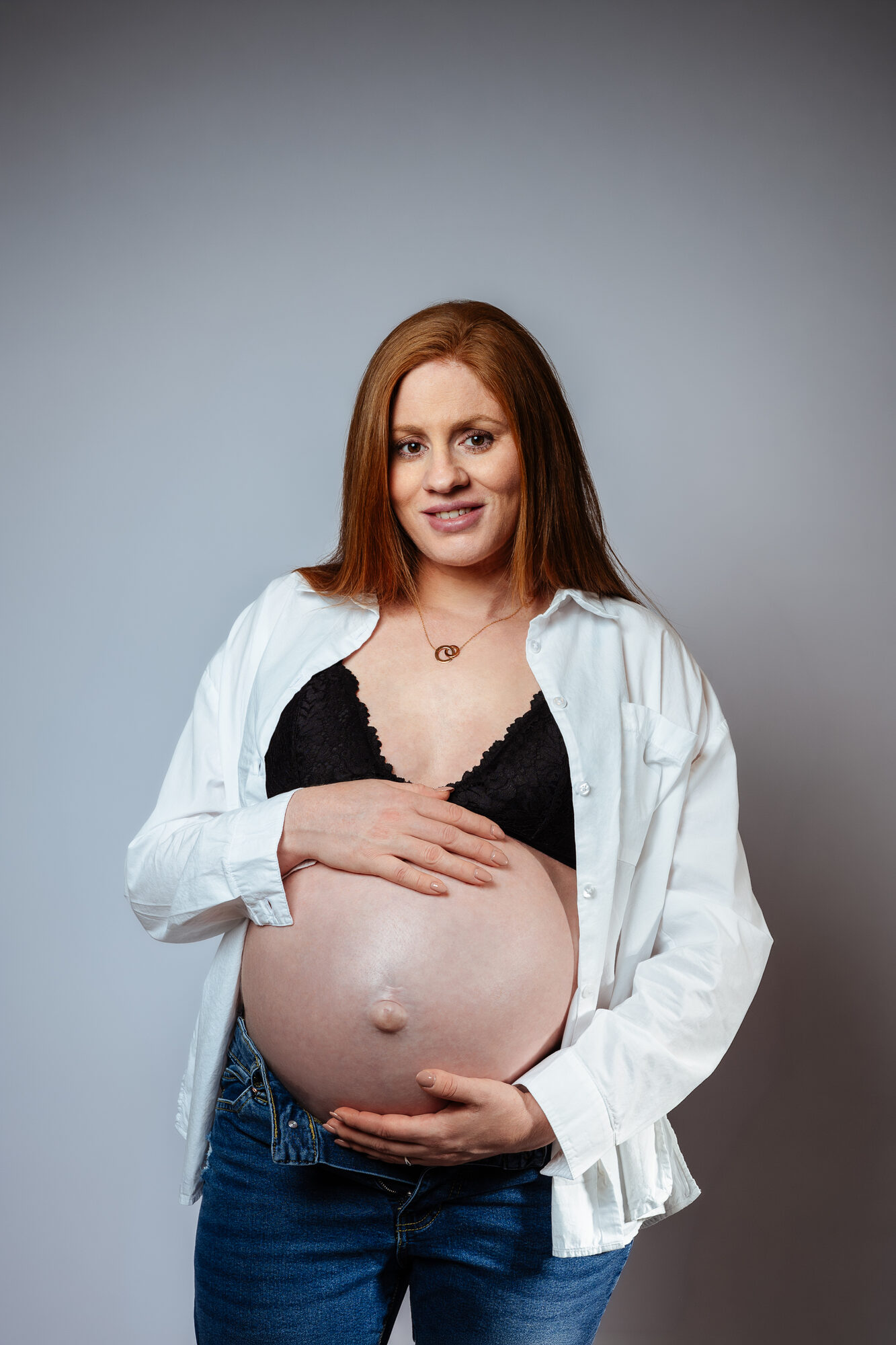 Femme enceinte souriante en chemise blanche
