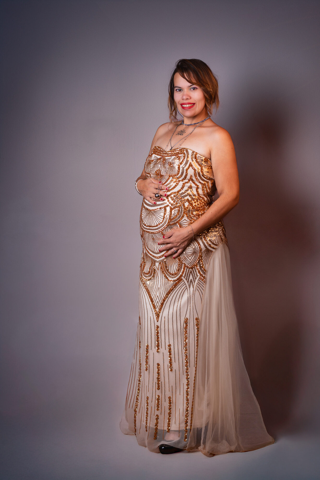 Femme enceinte en robe dorée