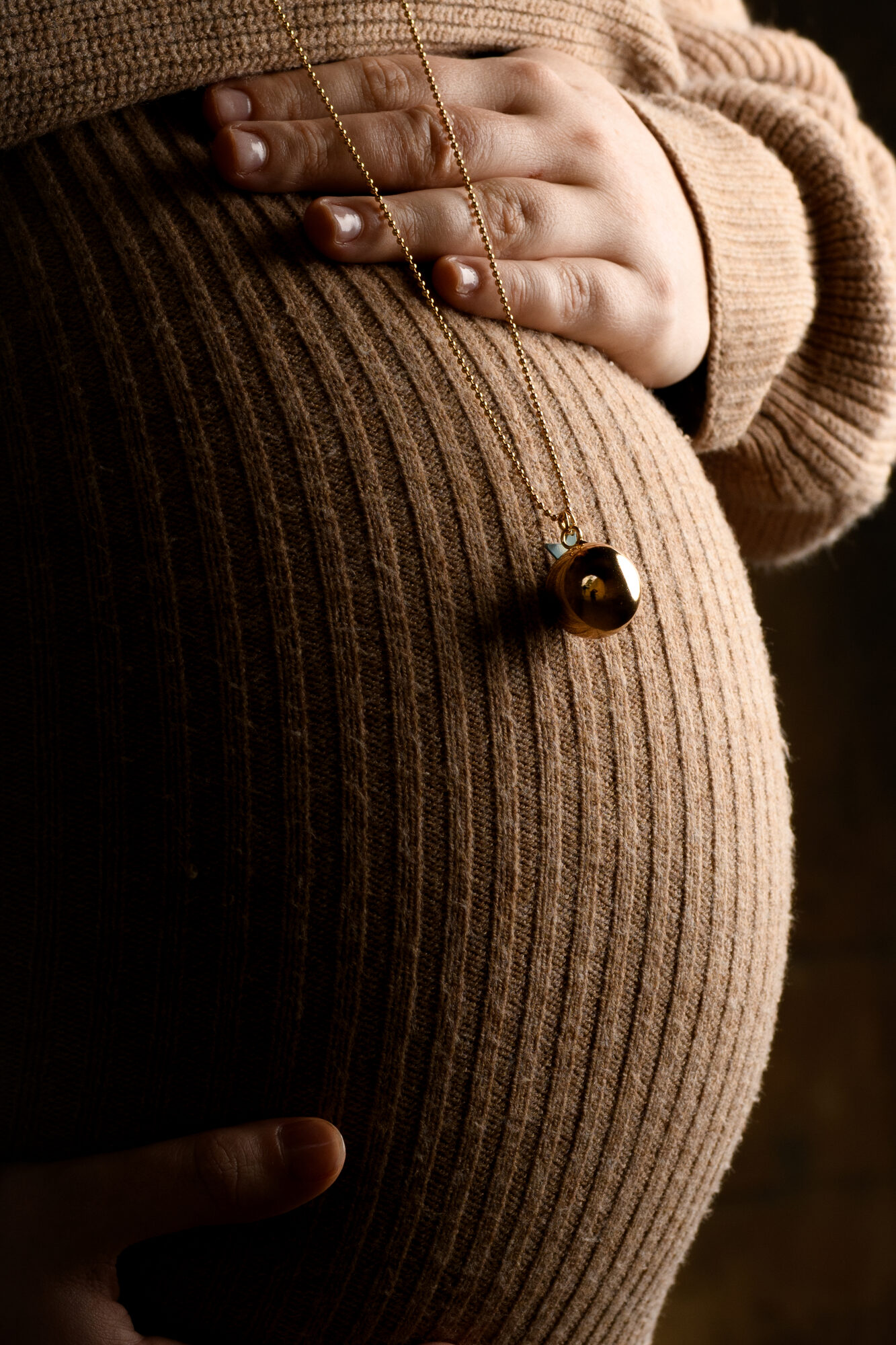 Détail collier sur ventre de femme enceinte